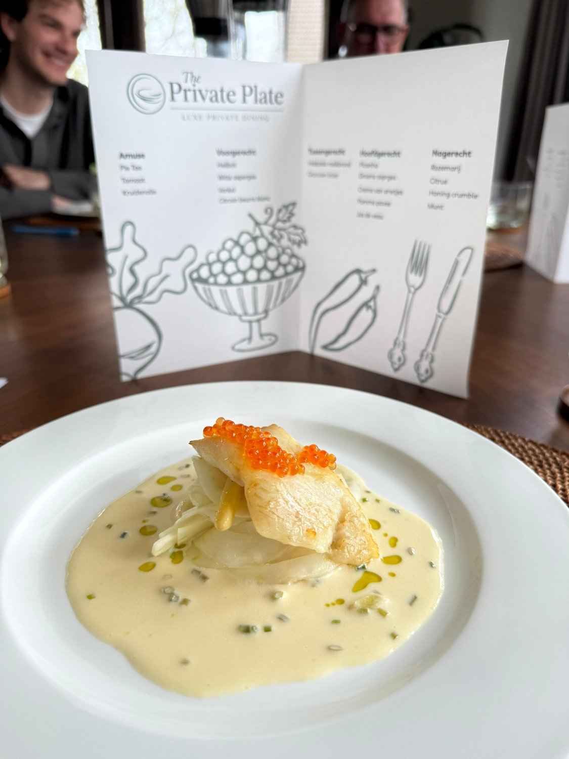 Een verfijnd visgerecht met het menu van The Private Plate aan tafel